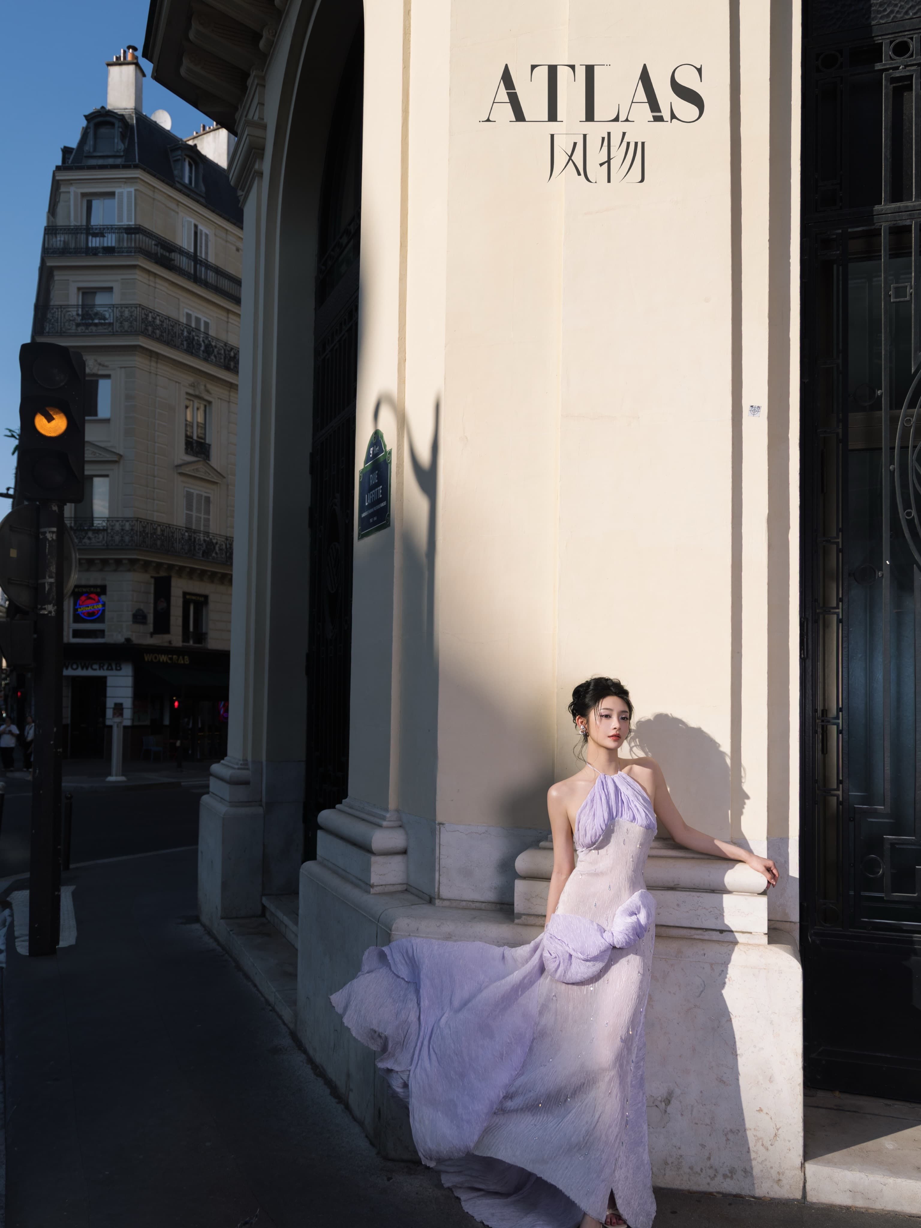 Zhou Jieqiong framed at a monumental Paris doorway in late afternoon light.