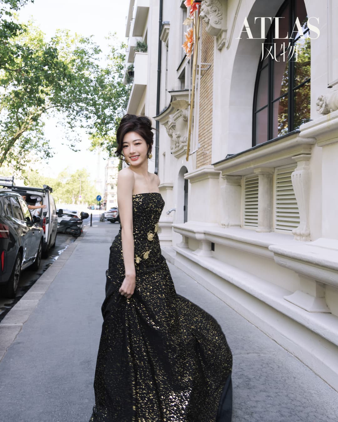Sun Leyan walking on a Paris street in a black-and-gold dress.
